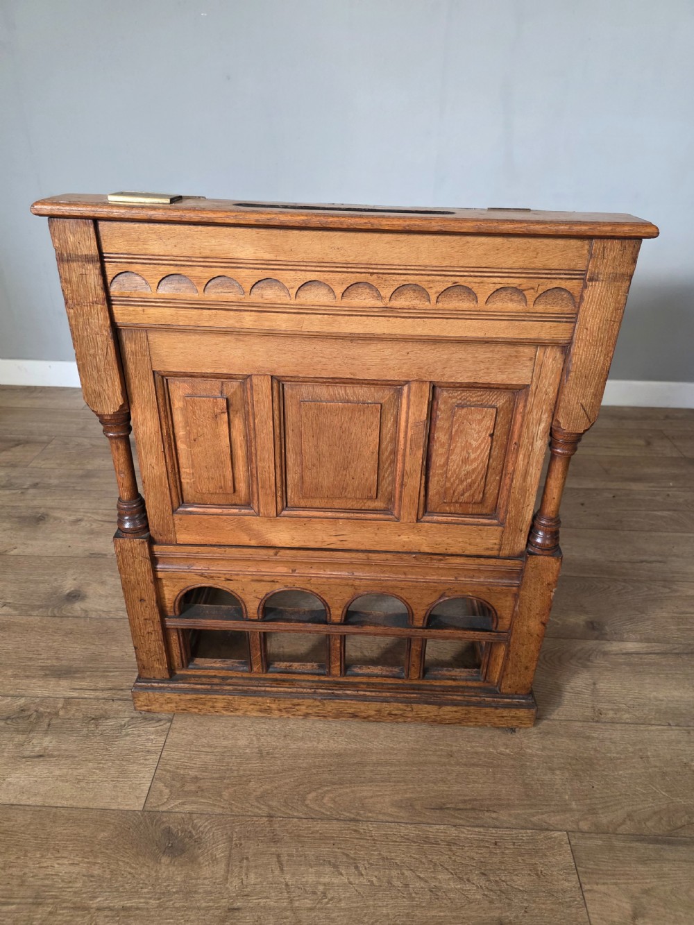 A late Victorian oak clerks desk with an inset green leather writing top, turned legs, and an arcaded lower framework. View XVI