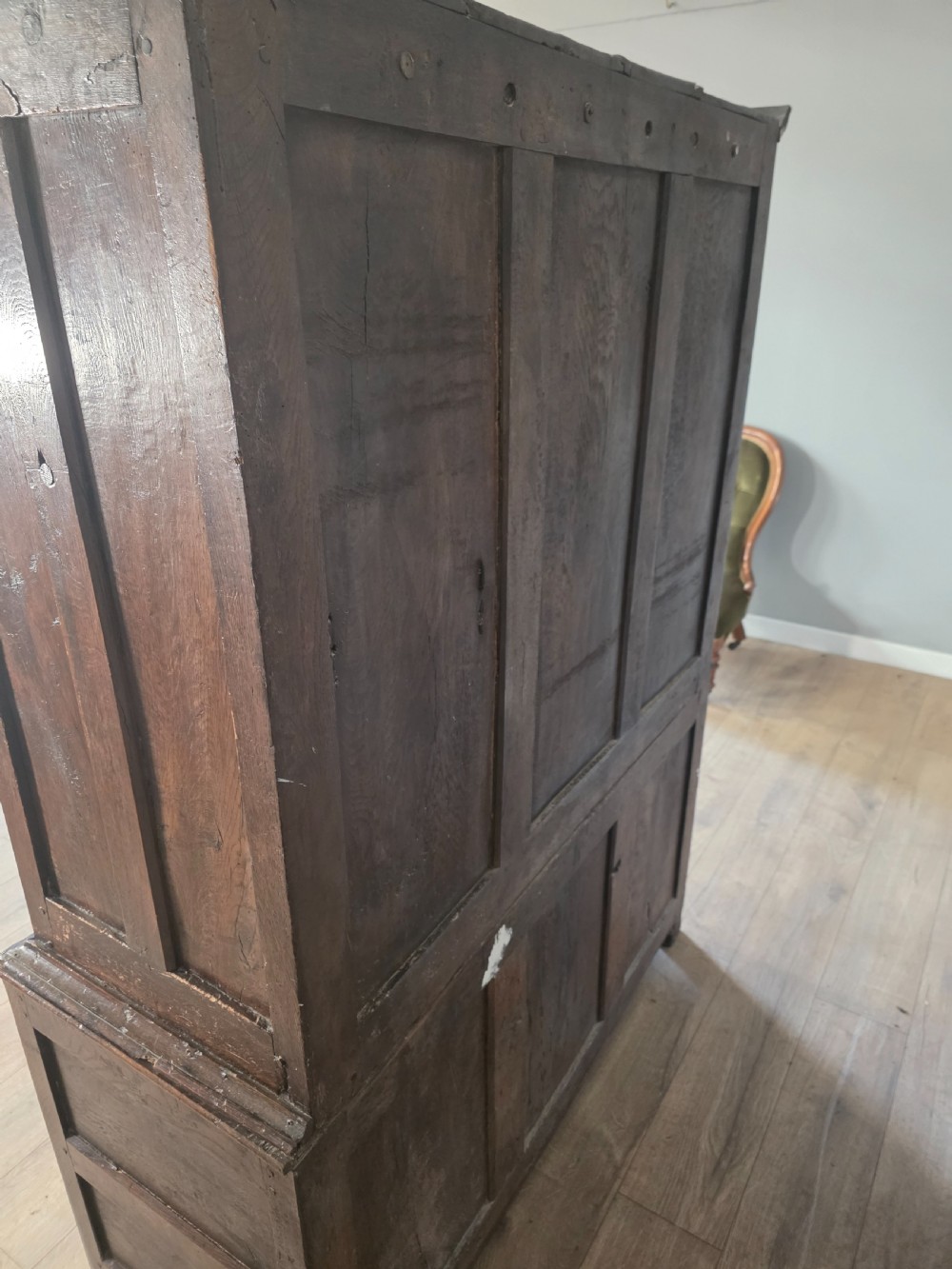 A dark oak two-tier antique cupboard with arched panel double doors above a base with recessed panels and two drawers. View XII