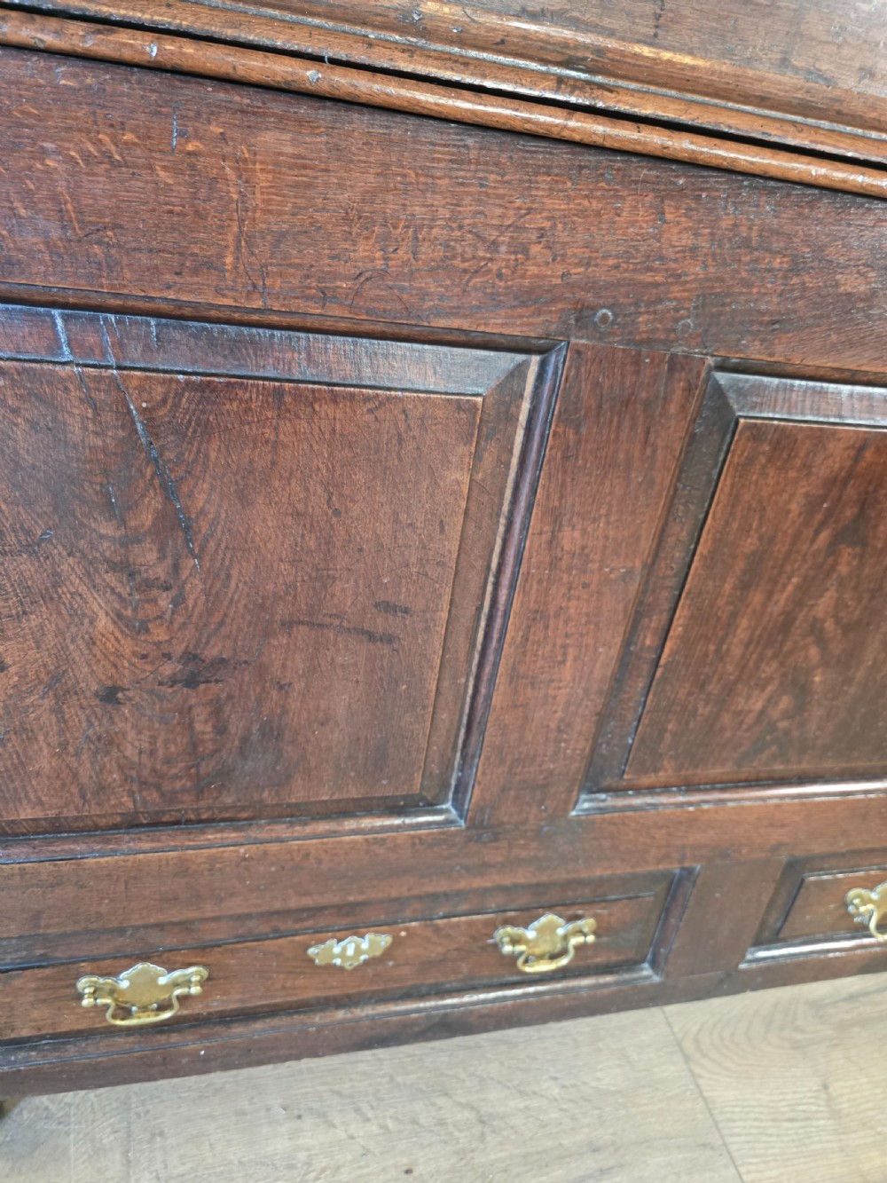 A dark oak two-tier antique cupboard with arched panel double doors above a base with recessed panels and two drawers. View XIV