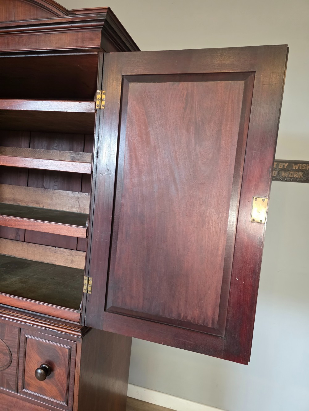 A late George III mahogany linen press featuring a double-door top cupboard under a arched pediment, resting on a lower section with drawers and bracket feet. View XI