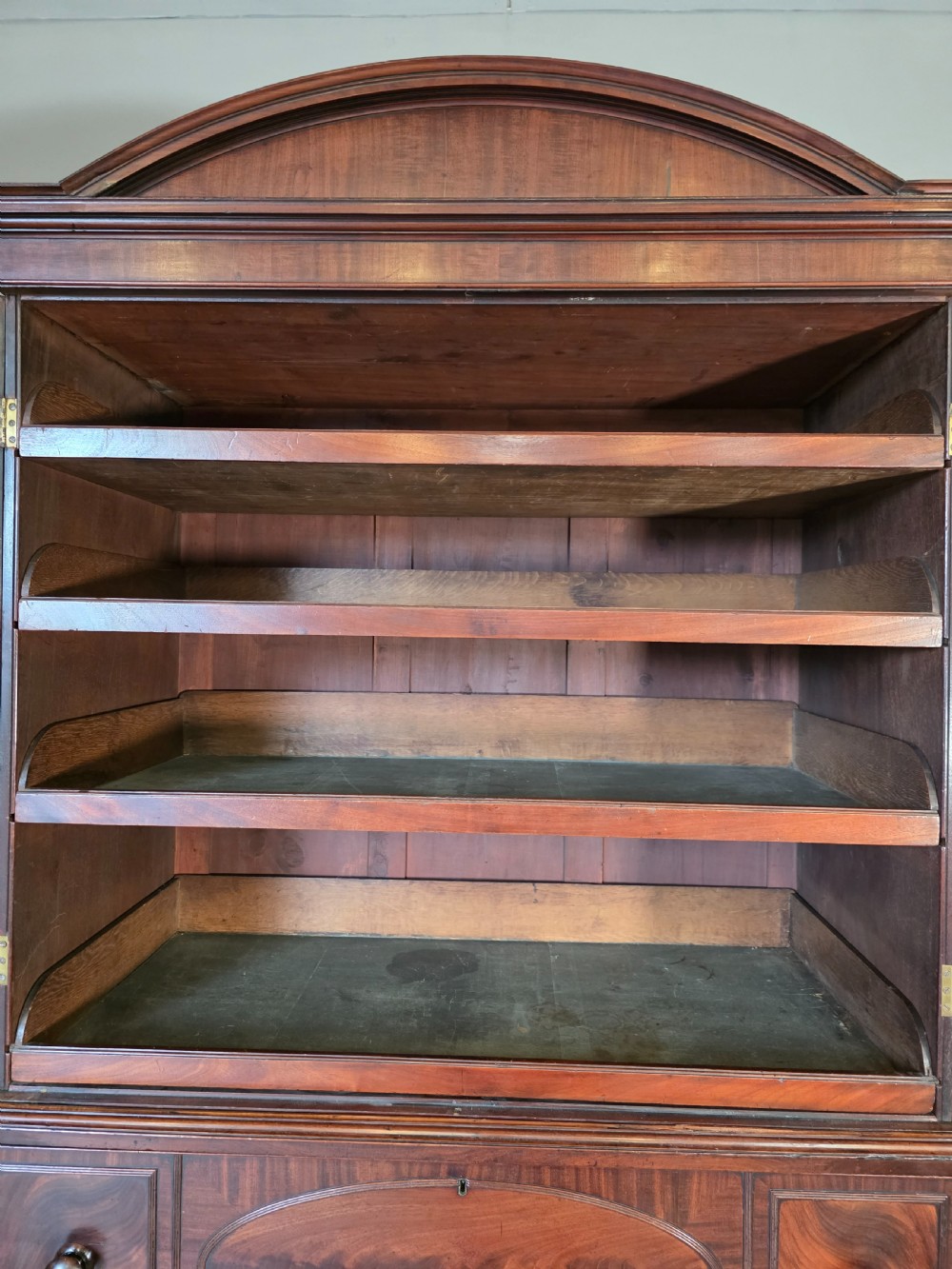 A late George III mahogany linen press featuring a double-door top cupboard under a arched pediment, resting on a lower section with drawers and bracket feet. View XII