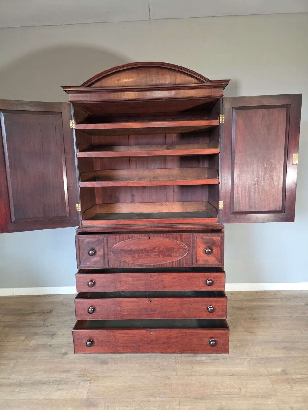 A late George III mahogany linen press featuring a double-door top cupboard under a arched pediment, resting on a lower section with drawers and bracket feet. View XIII