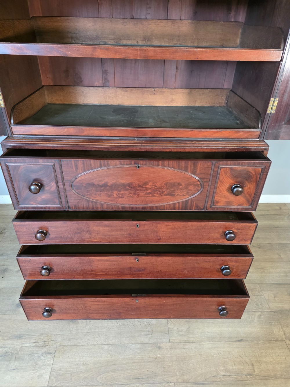 A late George III mahogany linen press featuring a double-door top cupboard under a arched pediment, resting on a lower section with drawers and bracket feet. View XIV