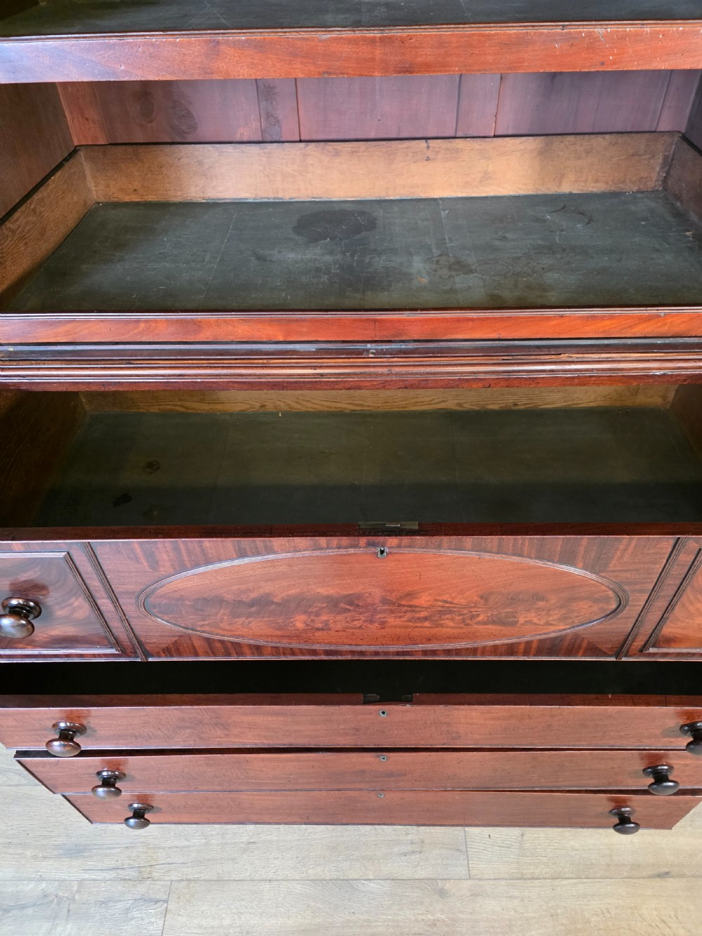 A late George III mahogany linen press featuring a double-door top cupboard under a arched pediment, resting on a lower section with drawers and bracket feet. View XV