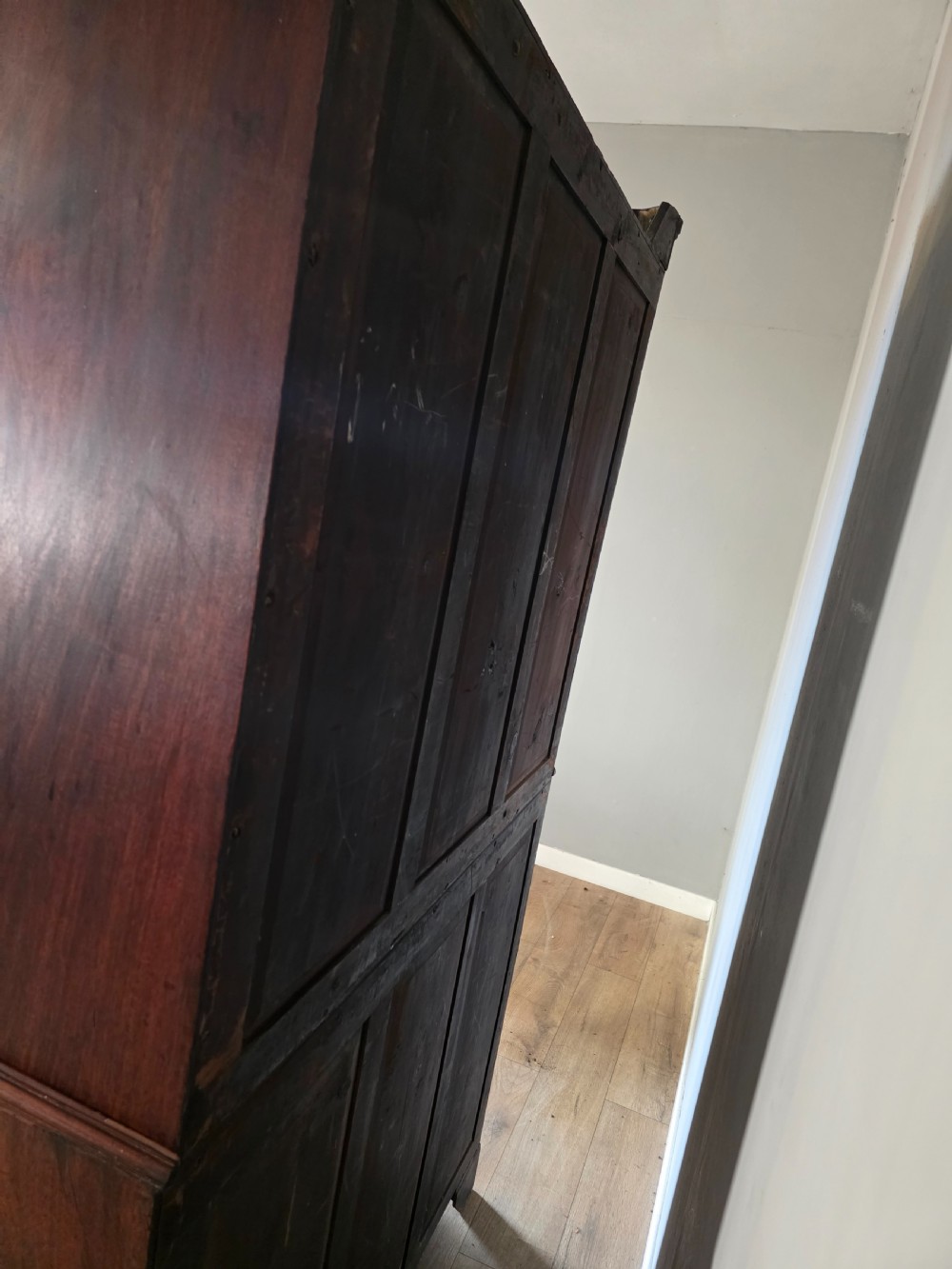 A late George III mahogany linen press featuring a double-door top cupboard under a arched pediment, resting on a lower section with drawers and bracket feet. View XVII