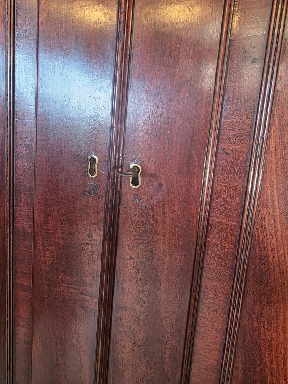 A late George III mahogany linen press featuring a double-door top cupboard under a arched pediment, resting on a lower section with drawers and bracket feet. View XVIII
