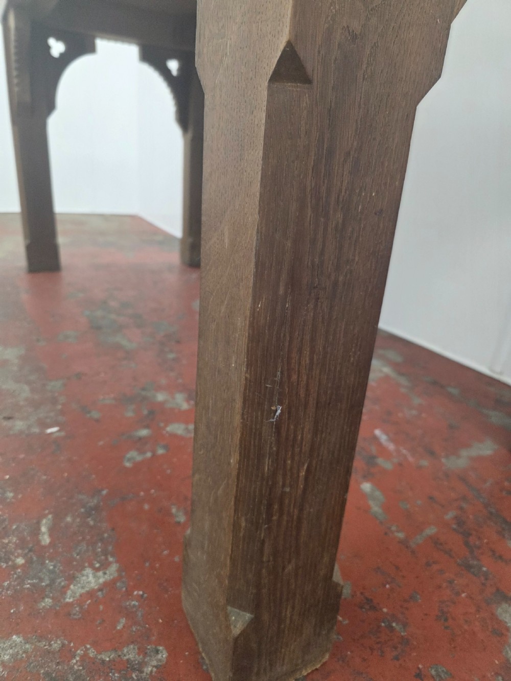 A rectangular dark oak console table featuring a notched dentil apron, carved corner spandrels, and sturdy chamfered legs. View XIV