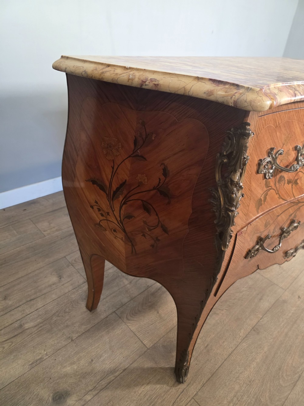 A French Louis XV style bombe commode featuring floral marquetry wood inlays, gilded metal mounts, cabriole legs, and a shaped pink-variegated marble top. View XI