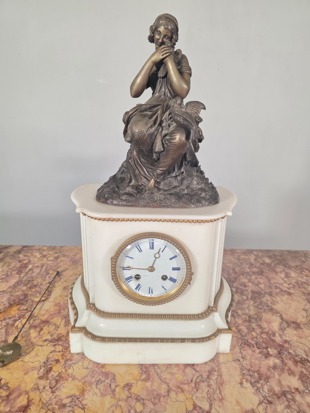 A late 19th-century French white marble mantel clock set featuring a patinated bronze seated female figure surmount, flanked by two matching marble tazze. View IX