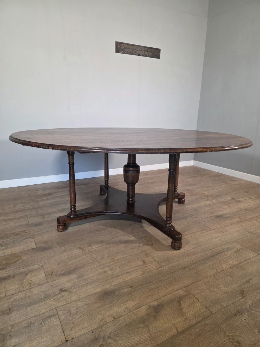 A large antique oval oak dining table featuring turned legs and a central stretcher base. View III