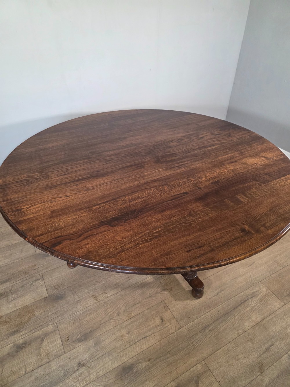 A large antique oval oak dining table featuring turned legs and a central stretcher base. View V