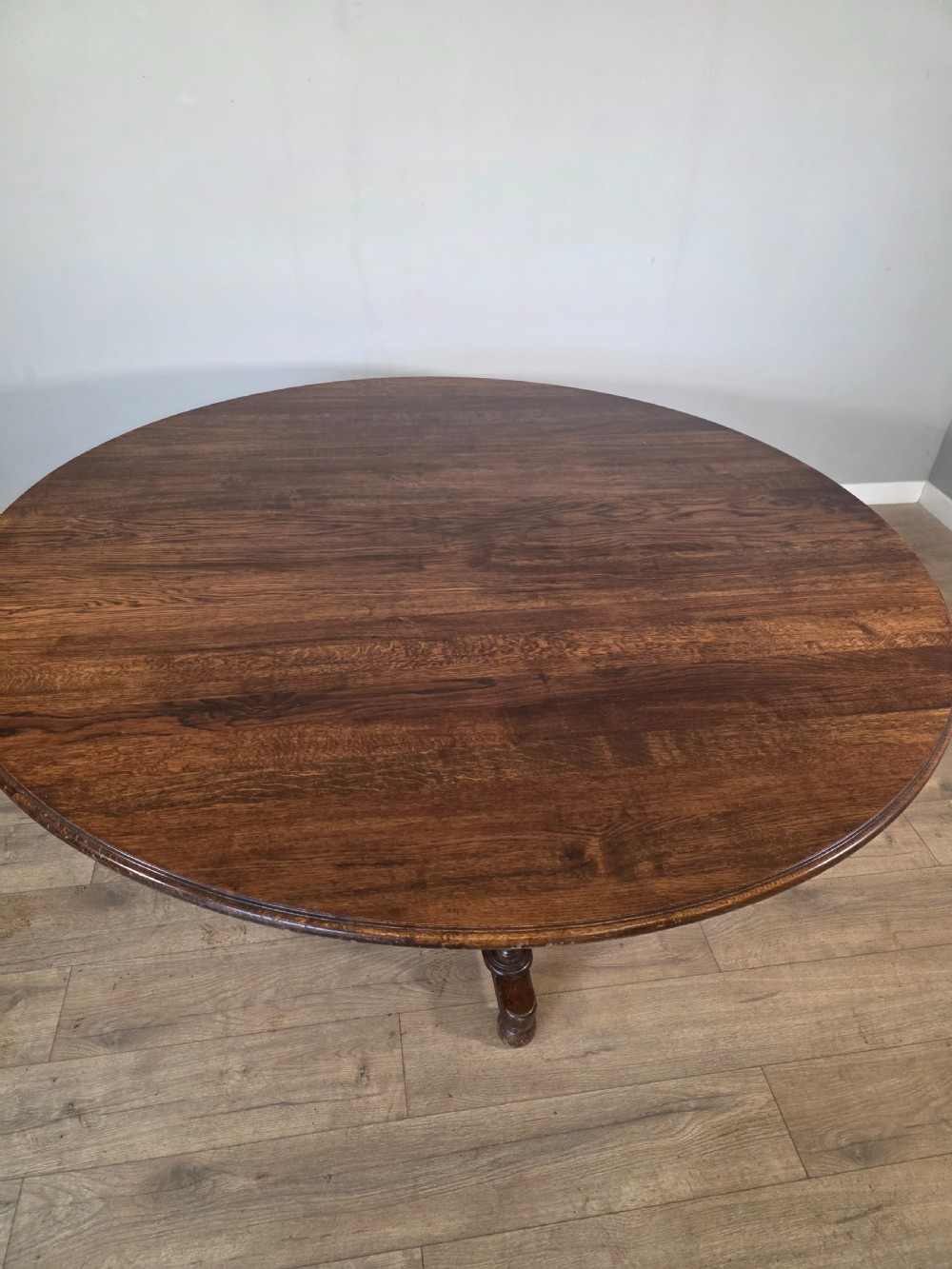 A large antique oval oak dining table featuring turned legs and a central stretcher base. View VIII