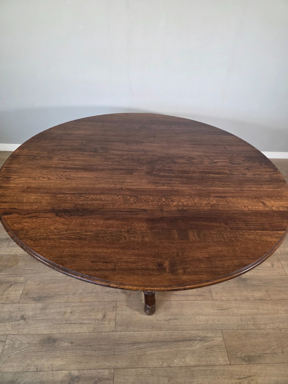 A large antique oval oak dining table featuring turned legs and a central stretcher base. View IX