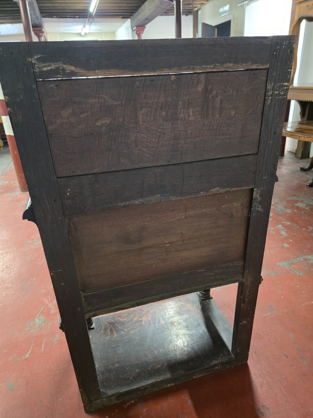 A dark brown late Victorian carved oak buffet featuring fielded panels, figural corbels, a tiered plate rack, and a lower undertier shelf. View XVII