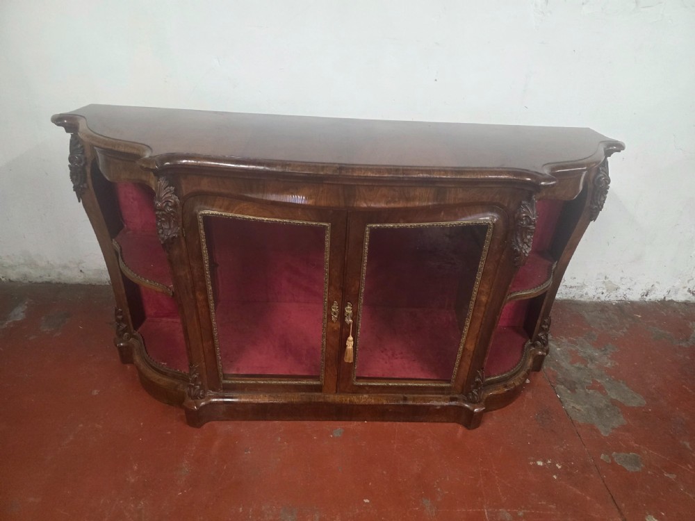 A Victorian rosewood credenza featuring central glazed double doors flanked by open curved side shelves with crimson fabric lining. View II
