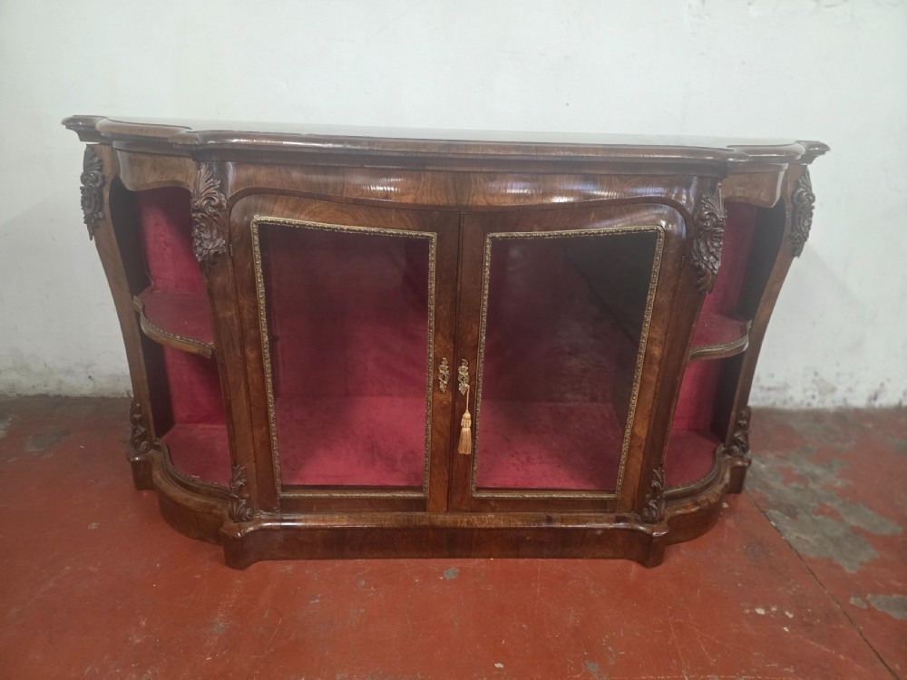 A Victorian rosewood credenza featuring central glazed double doors flanked by open curved side shelves with crimson fabric lining. View V
