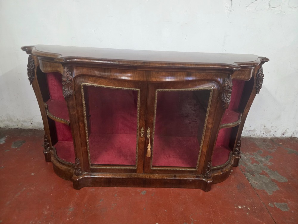 A Victorian rosewood credenza featuring central glazed double doors flanked by open curved side shelves with crimson fabric lining. View VII