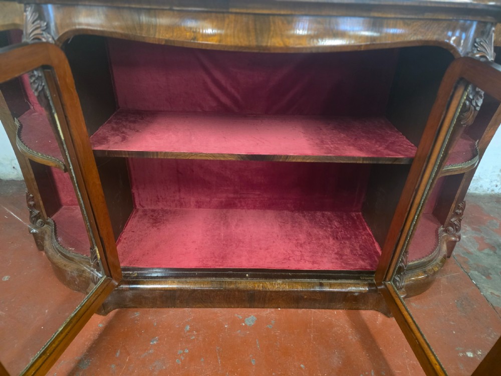 A Victorian rosewood credenza featuring central glazed double doors flanked by open curved side shelves with crimson fabric lining. View IX