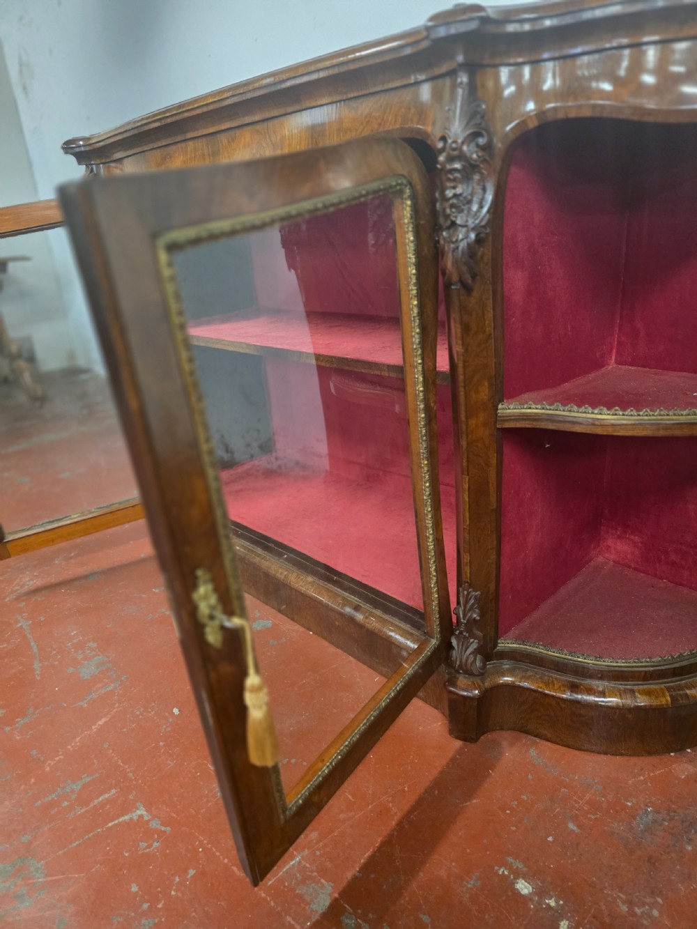 A Victorian rosewood credenza featuring central glazed double doors flanked by open curved side shelves with crimson fabric lining. View X