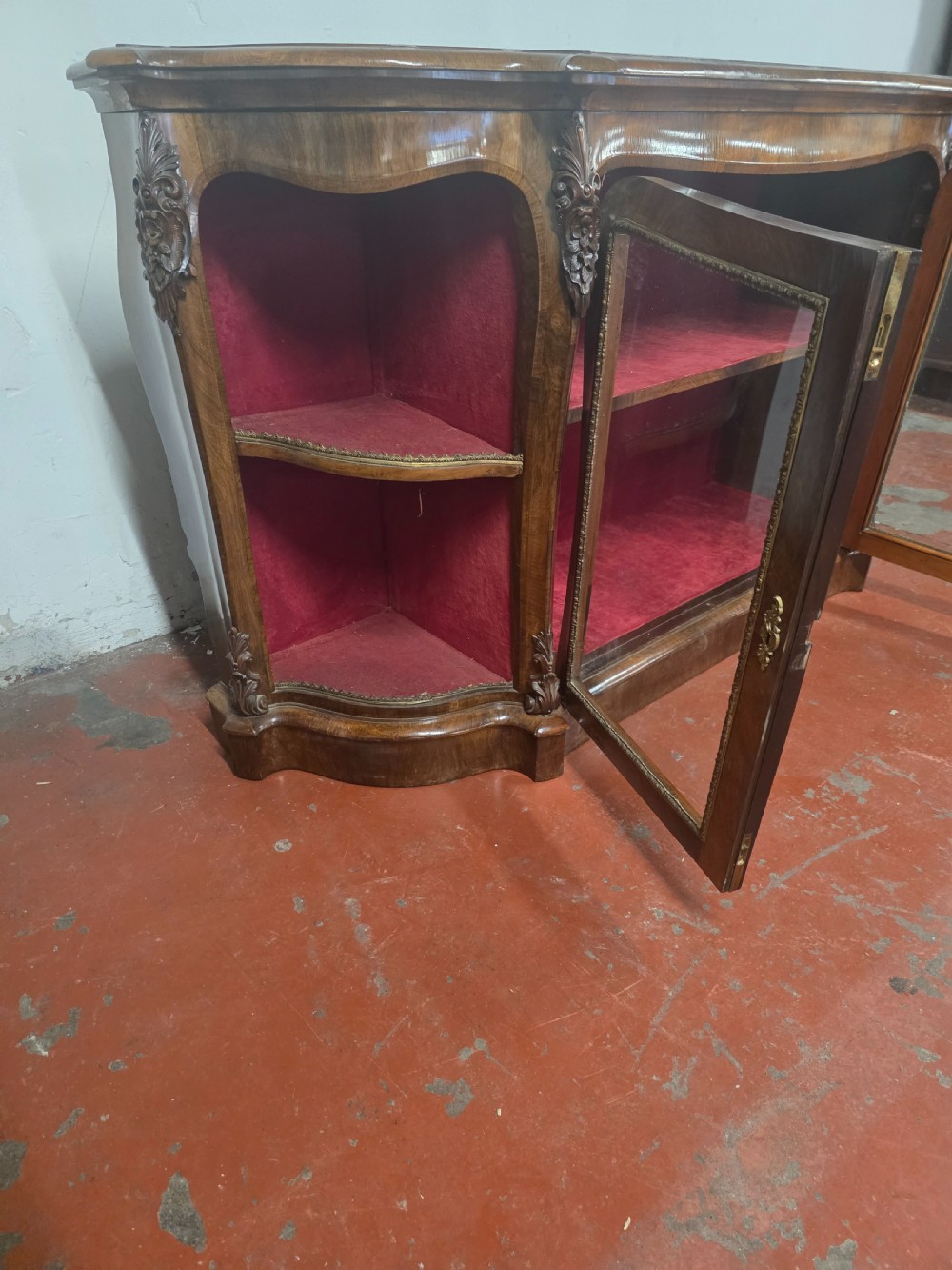 A Victorian rosewood credenza featuring central glazed double doors flanked by open curved side shelves with crimson fabric lining. View XII