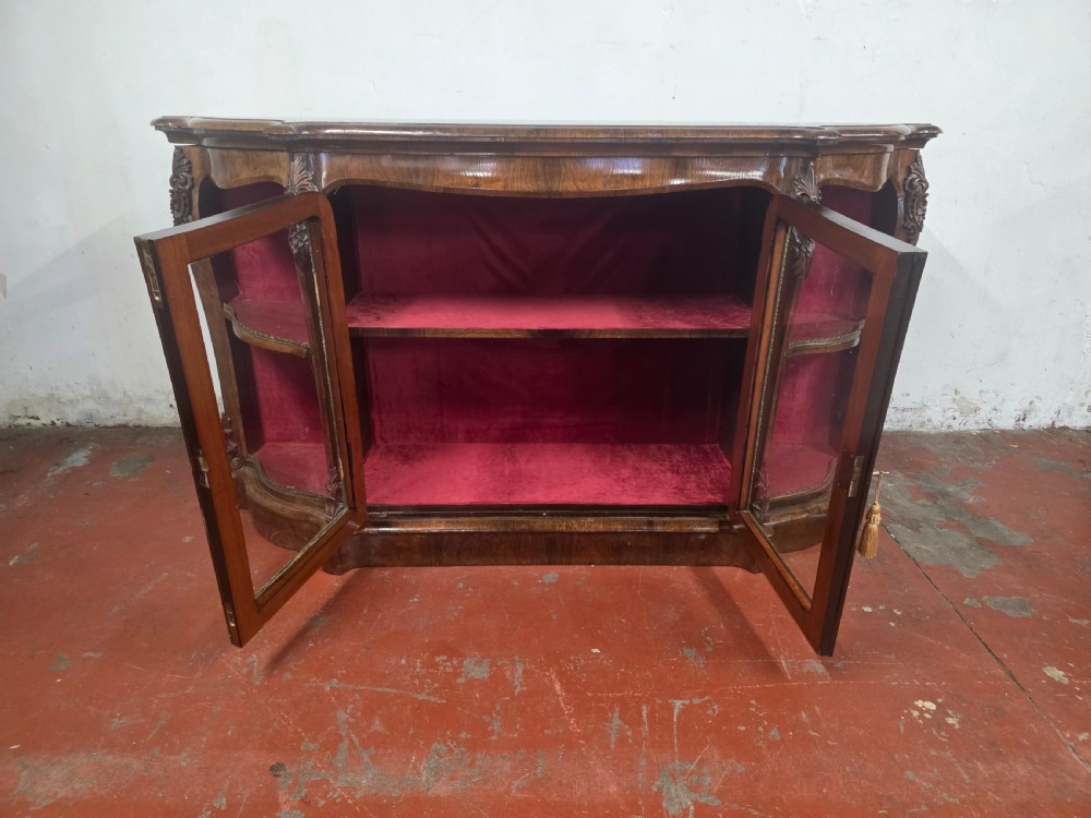A Victorian rosewood credenza featuring central glazed double doors flanked by open curved side shelves with crimson fabric lining. View XIV
