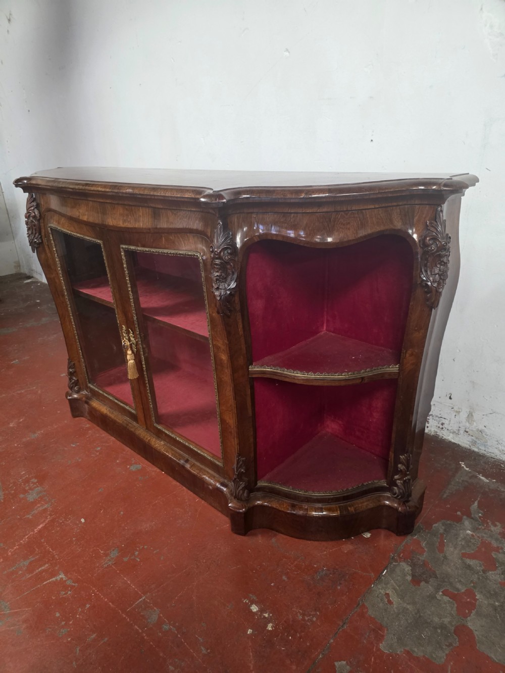 A Victorian rosewood credenza featuring central glazed double doors flanked by open curved side shelves with crimson fabric lining. View XVII
