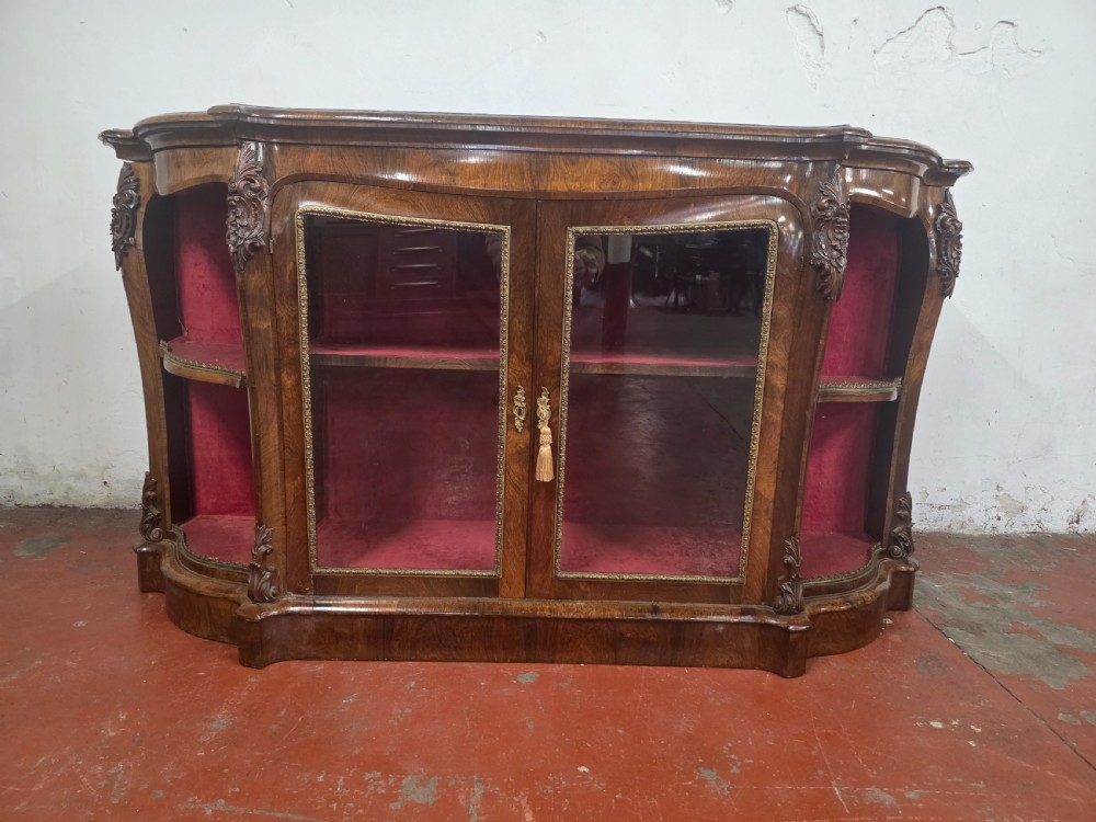 A Victorian rosewood credenza featuring central glazed double doors flanked by open curved side shelves with crimson fabric lining. View XVIII