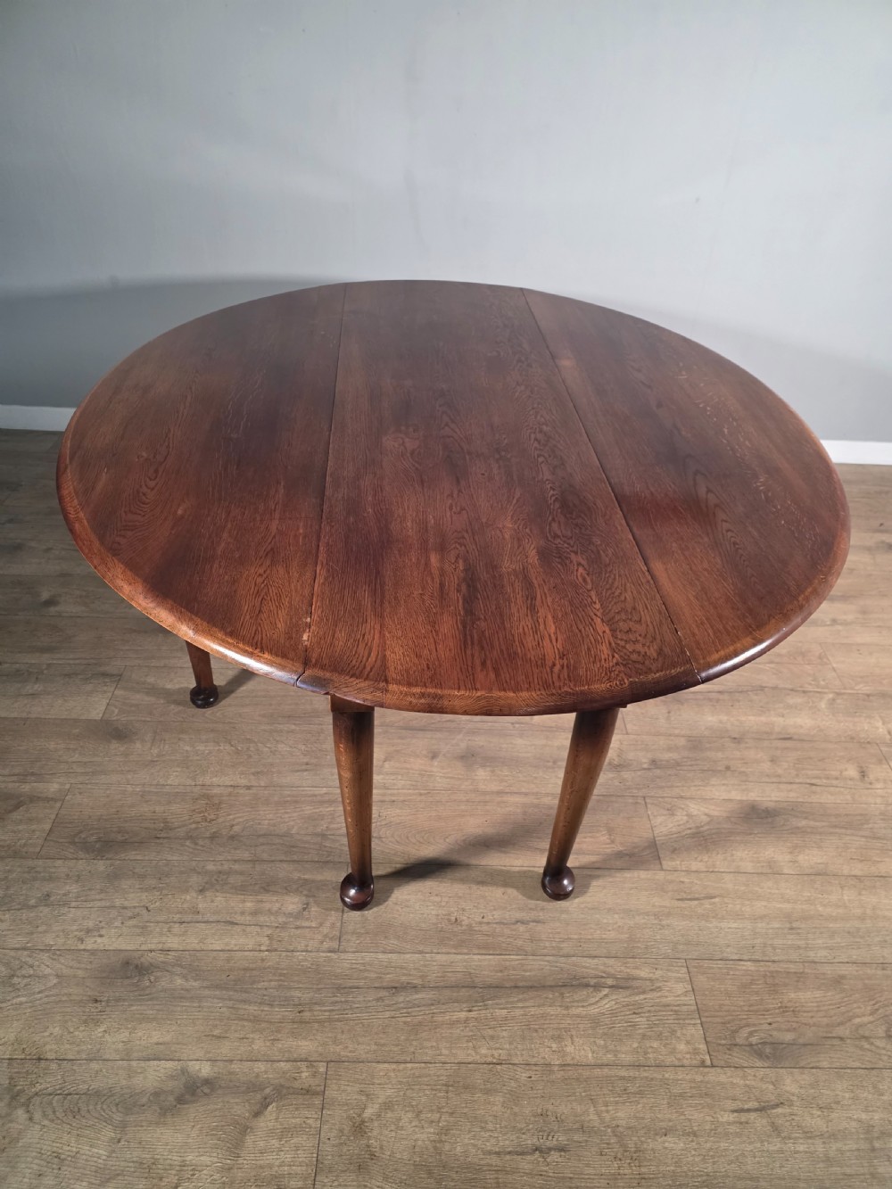A large oval solid oak drop-leaf wake dining table featuring tapered legs with pad feet. View V