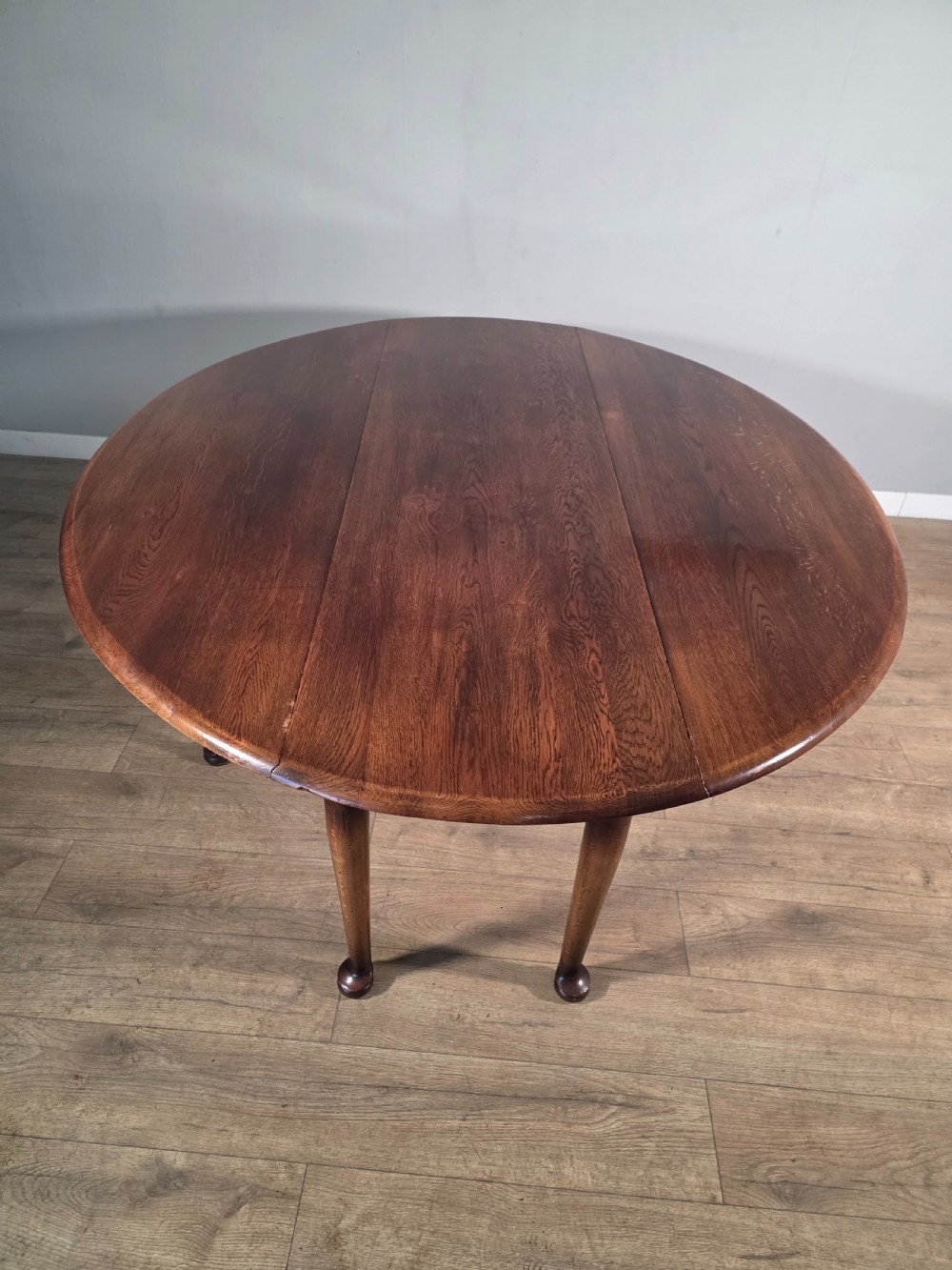A large oval solid oak drop-leaf wake dining table featuring tapered legs with pad feet. View VIII