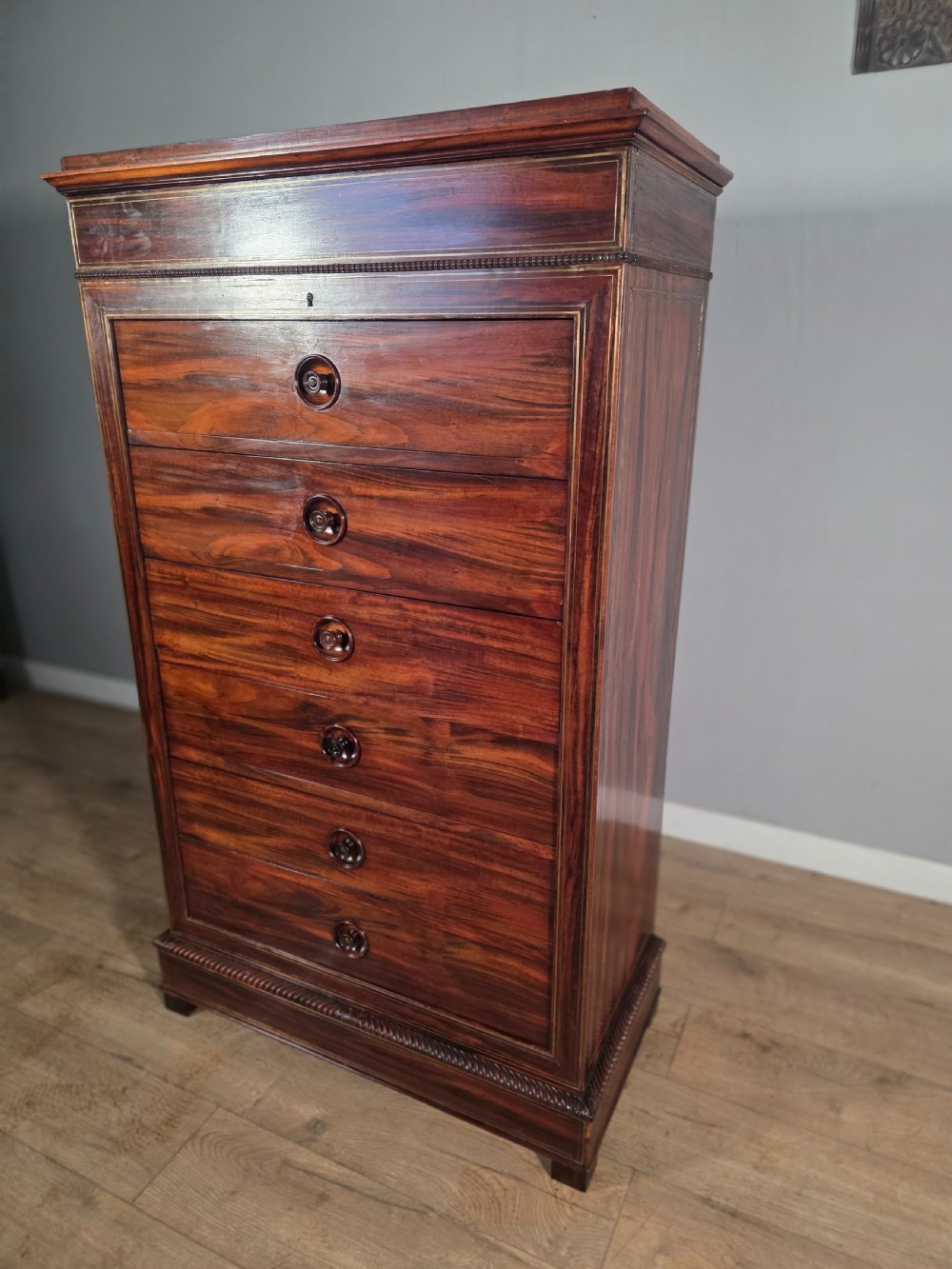 A tall 19th-century French rosewood chest featuring six drawers decorated with brass inlay stringing and turned wooden handles. View IV