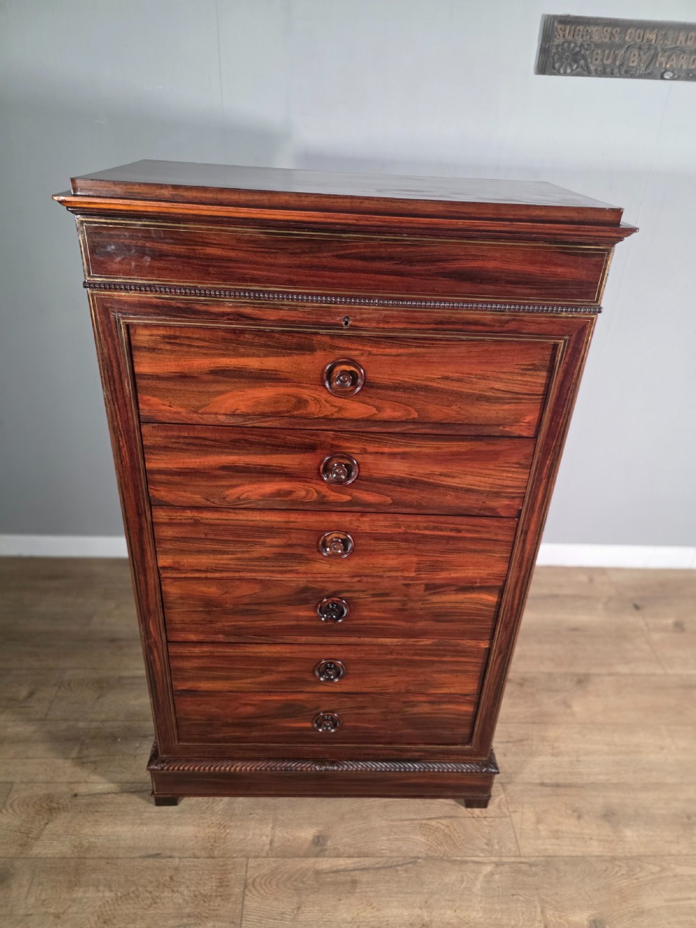 A tall 19th-century French rosewood chest featuring six drawers decorated with brass inlay stringing and turned wooden handles. View VI