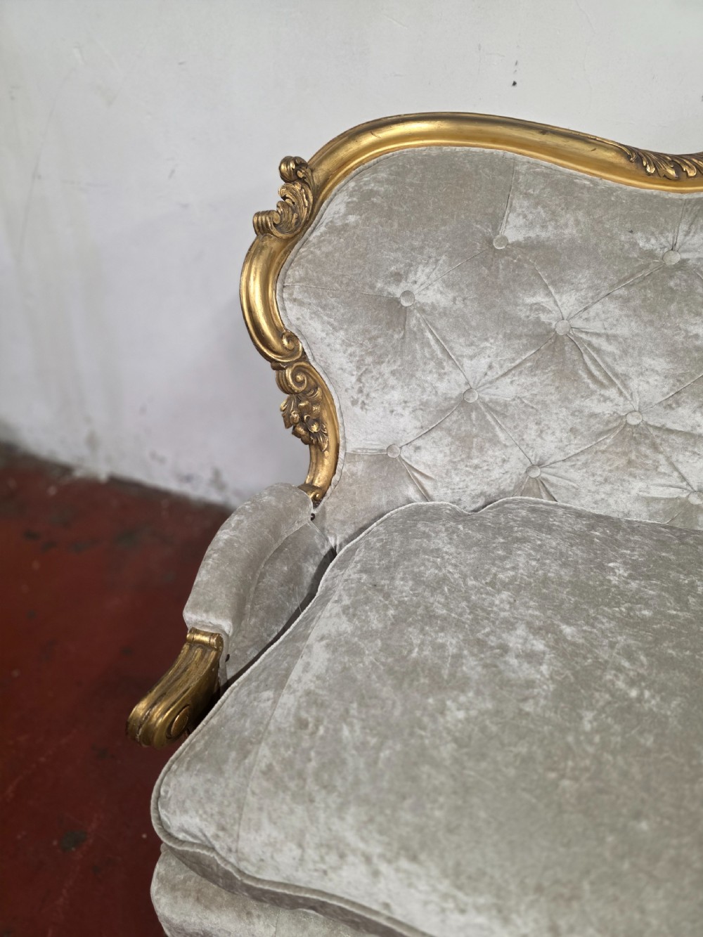 A late 19th-century Victorian Rococo Revival sofa with a carved gold giltwood frame, deep button-tufted light grey velvet backrest, and cabriole legs. View XI