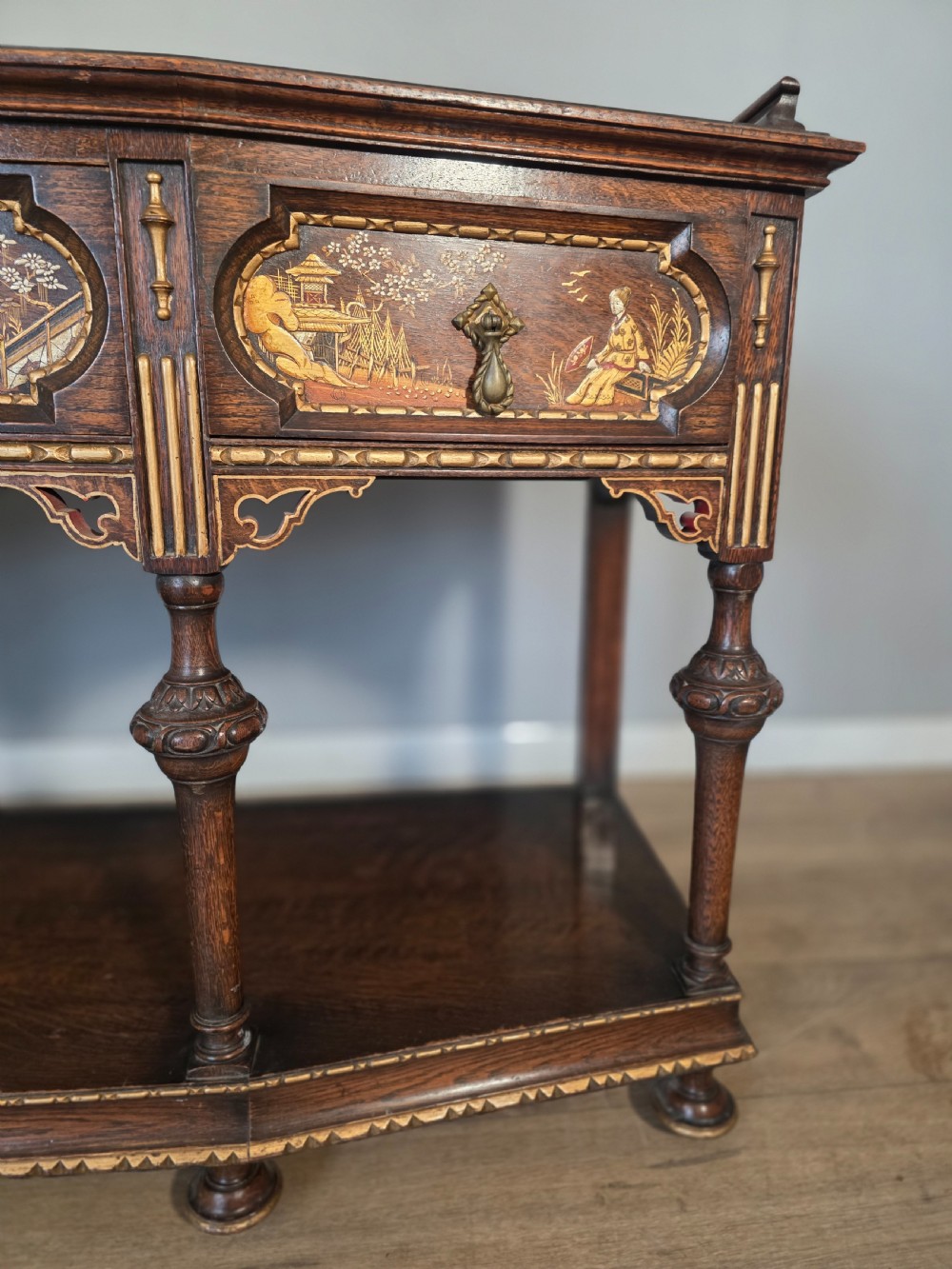 An antique solid oak console table featuring carved drawers, inlaid details, turned supports, and an undertier shelf. View XIII