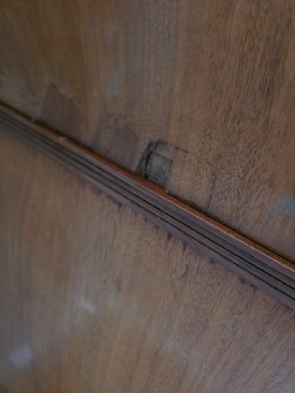 A George III mahogany linen press featuring flame mahogany panelled cupboard doors above a base of four drawers. View XVII