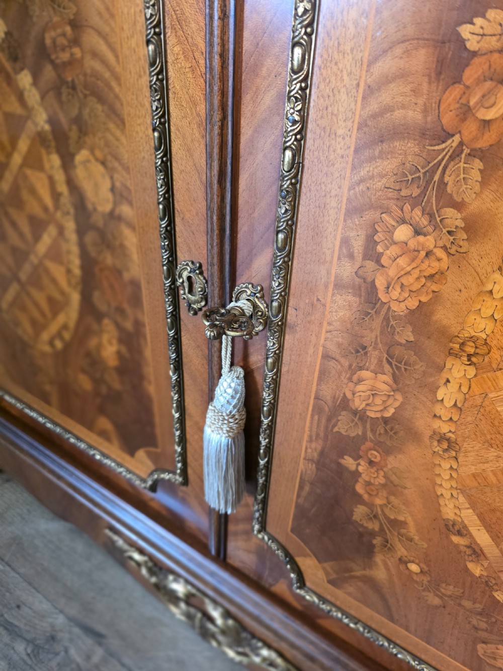 A 1920s French wooden cupboard featuring intricate floral marquetry inlay, gilt metal mounts, a single top drawer, two cabinet doors, and a reddish marble top surface. View VII