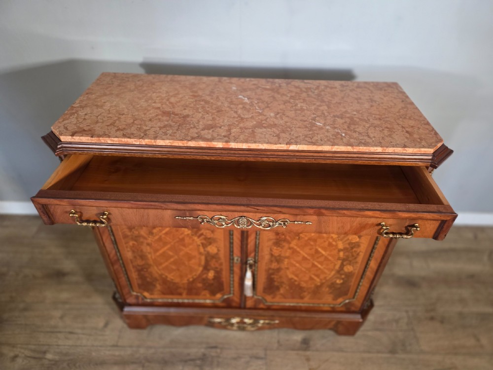 A 1920s French wooden cupboard featuring intricate floral marquetry inlay, gilt metal mounts, a single top drawer, two cabinet doors, and a reddish marble top surface. View XI