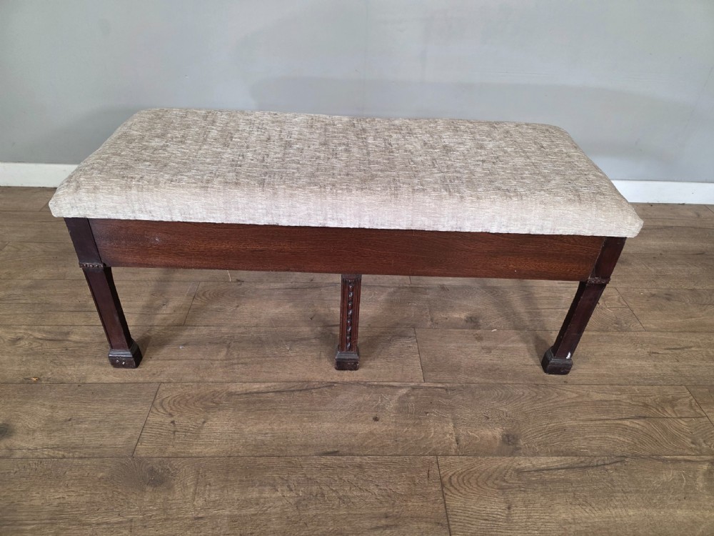 An 18th-century Adam style dark mahogany long window seat with six square tapered legs and a beige textured upholstered seat. View III