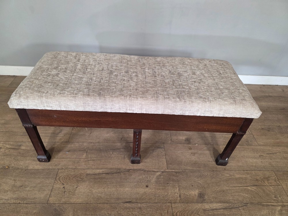 An 18th-century Adam style dark mahogany long window seat with six square tapered legs and a beige textured upholstered seat. View IV
