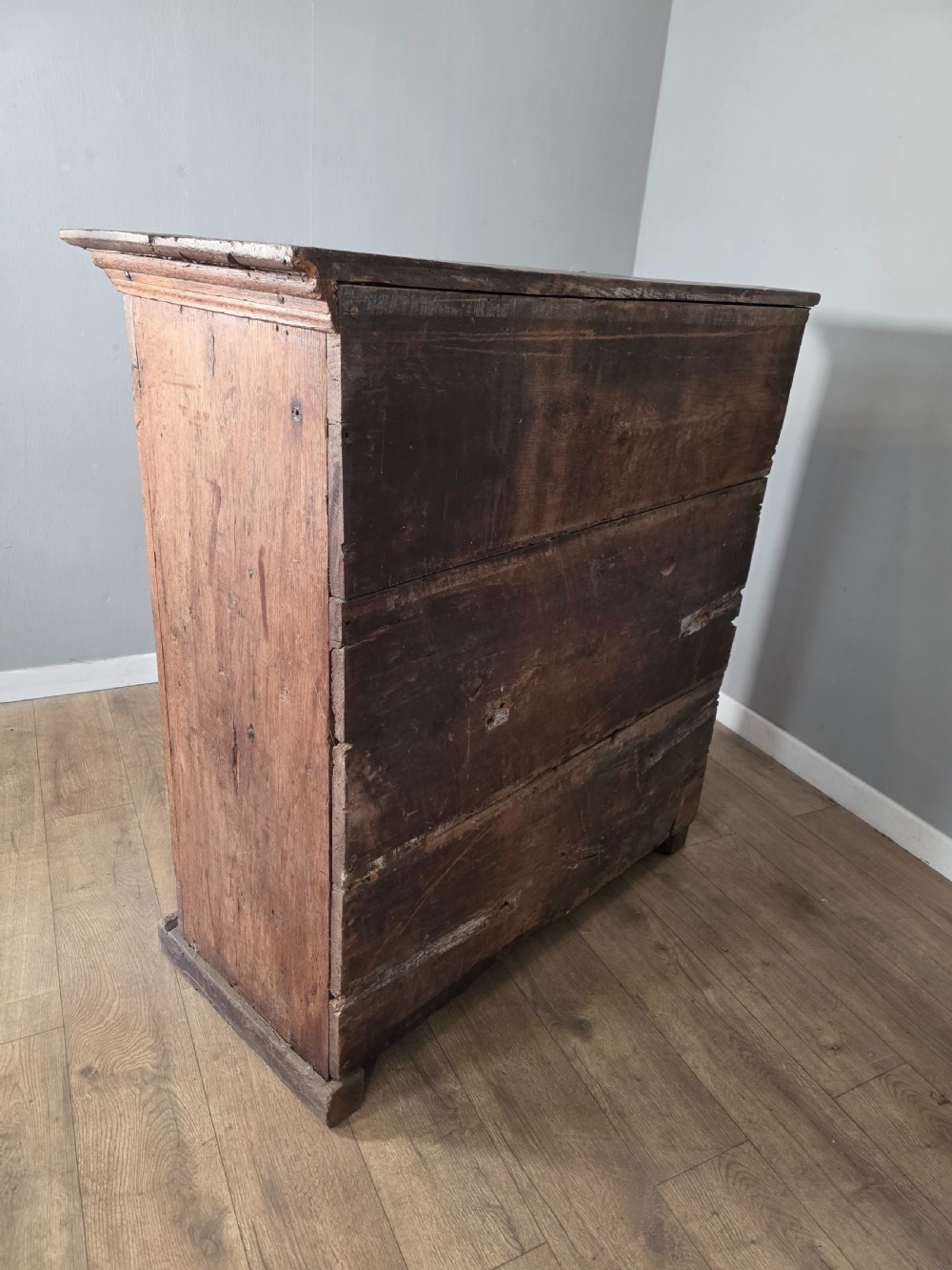 An 18th-century primitive dark oak cupboard featuring two panelled doors with notch carving, wrought iron escutcheons, and moulded top cornicing. View XIV
