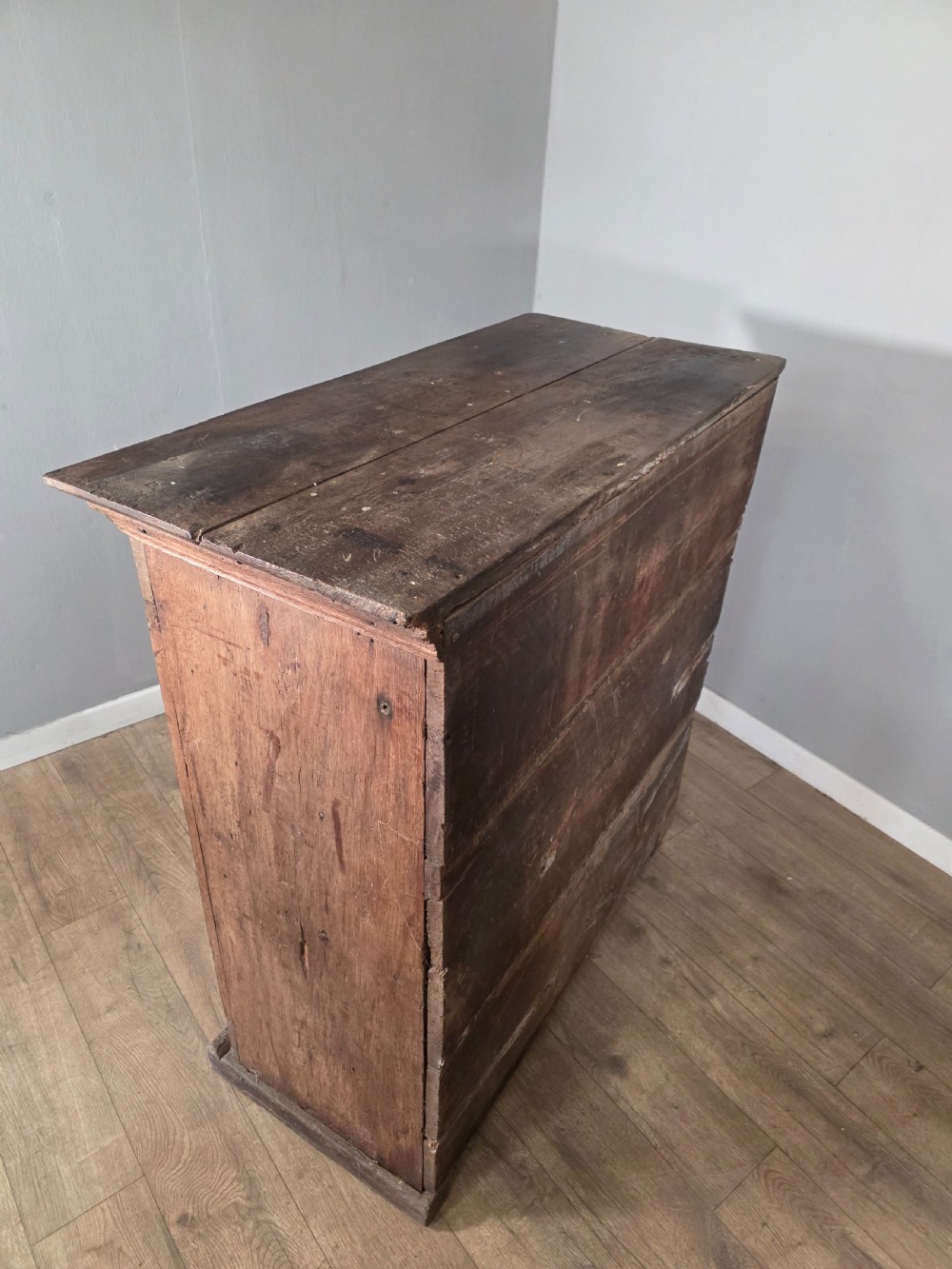 An 18th-century primitive dark oak cupboard featuring two panelled doors with notch carving, wrought iron escutcheons, and moulded top cornicing. View XV