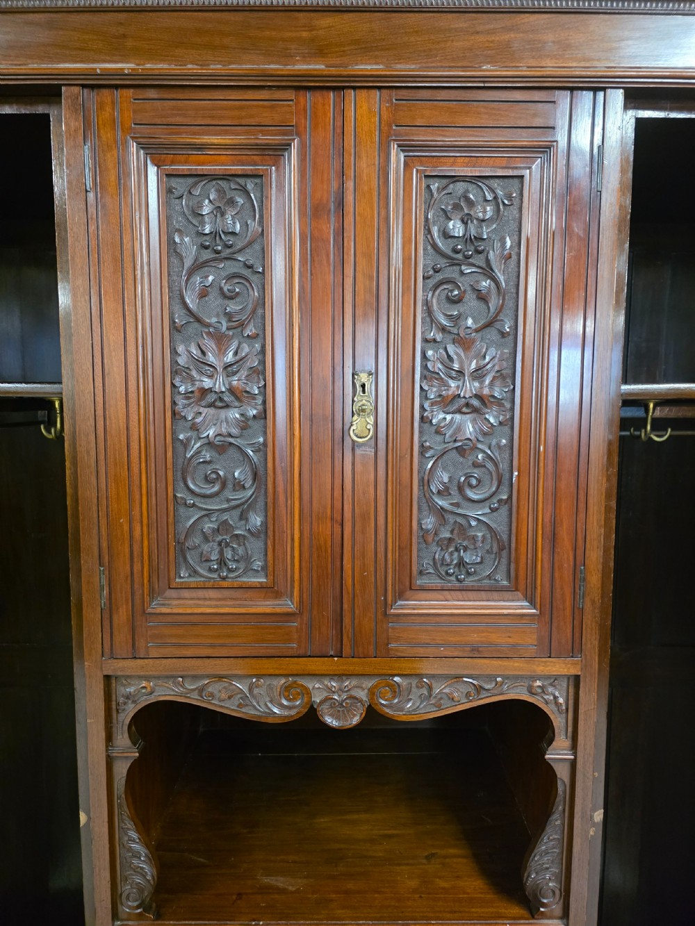 A late Victorian walnut combination wardrobe featuring twin mirrored doors flanking a central section of carved cupboards, an open shelf niche, and five burr walnut drawers. View XII