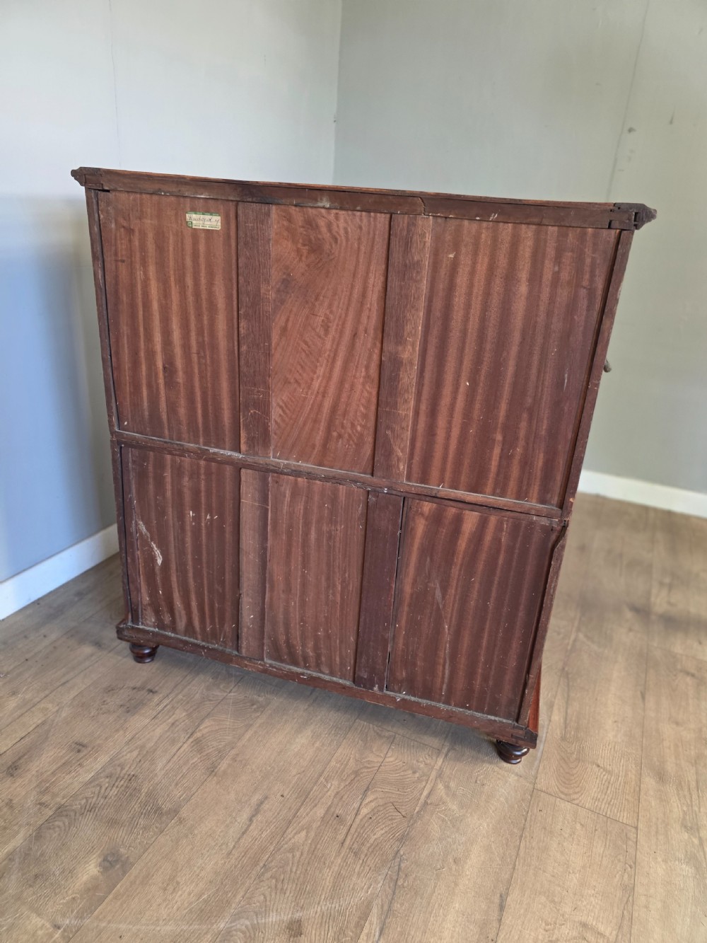 A 19th-century teak military campaign chest of drawers featuring a two-part split design with flush brass handles and turned feet. View X