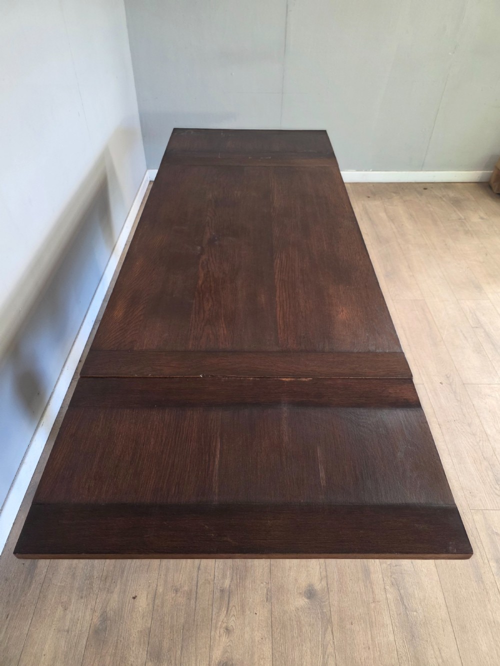 A solid dark oak extending dining table featuring carved bulbous legs, a decorative foliage apron, and a stretcher base. View XIII