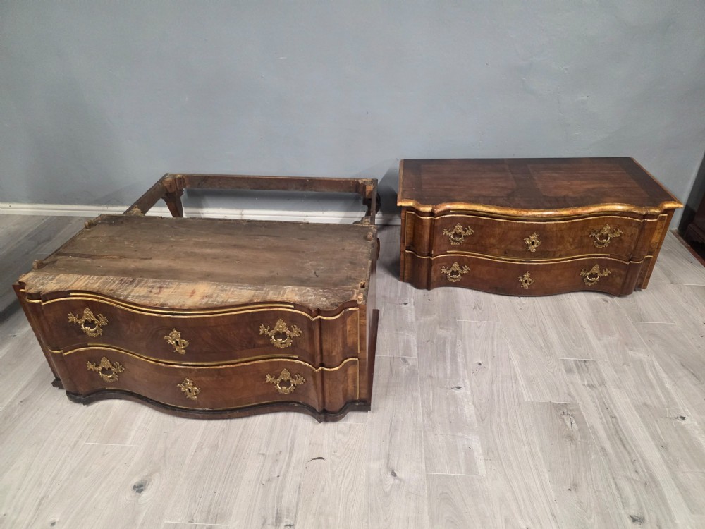 An 18th-century walnut chest of drawers featuring a serpentine front, four drawers, ornate brass handles, and short cabriole legs. View XV