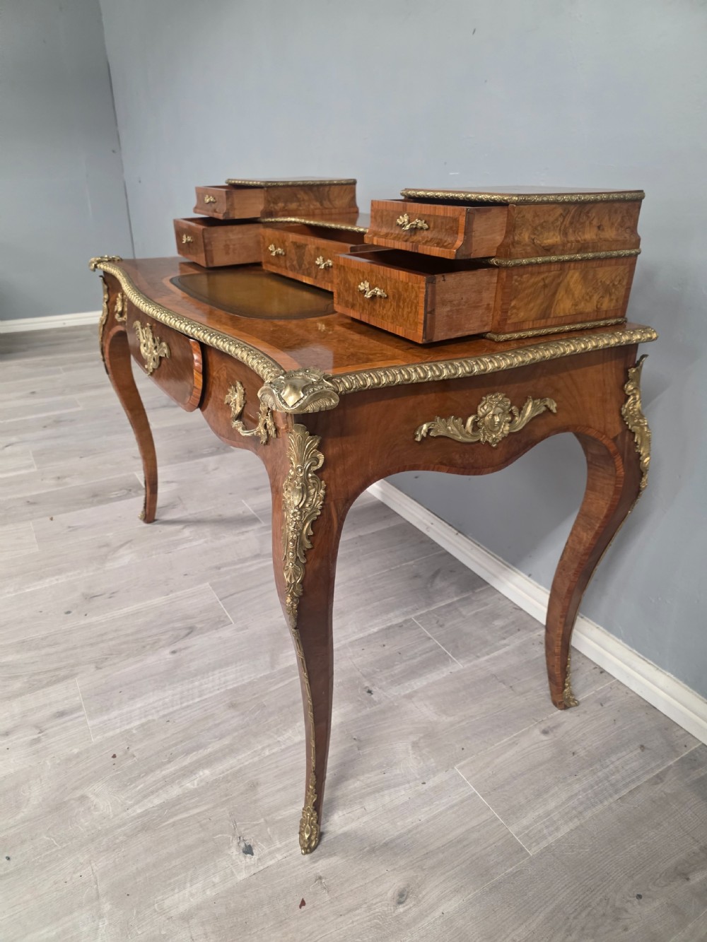 A 19th-century French Rococo Revival writing desk crafted from burr walnut with gilt-bronze mounts, a central leather writing insert, and a raised superstructure of drawers. View III