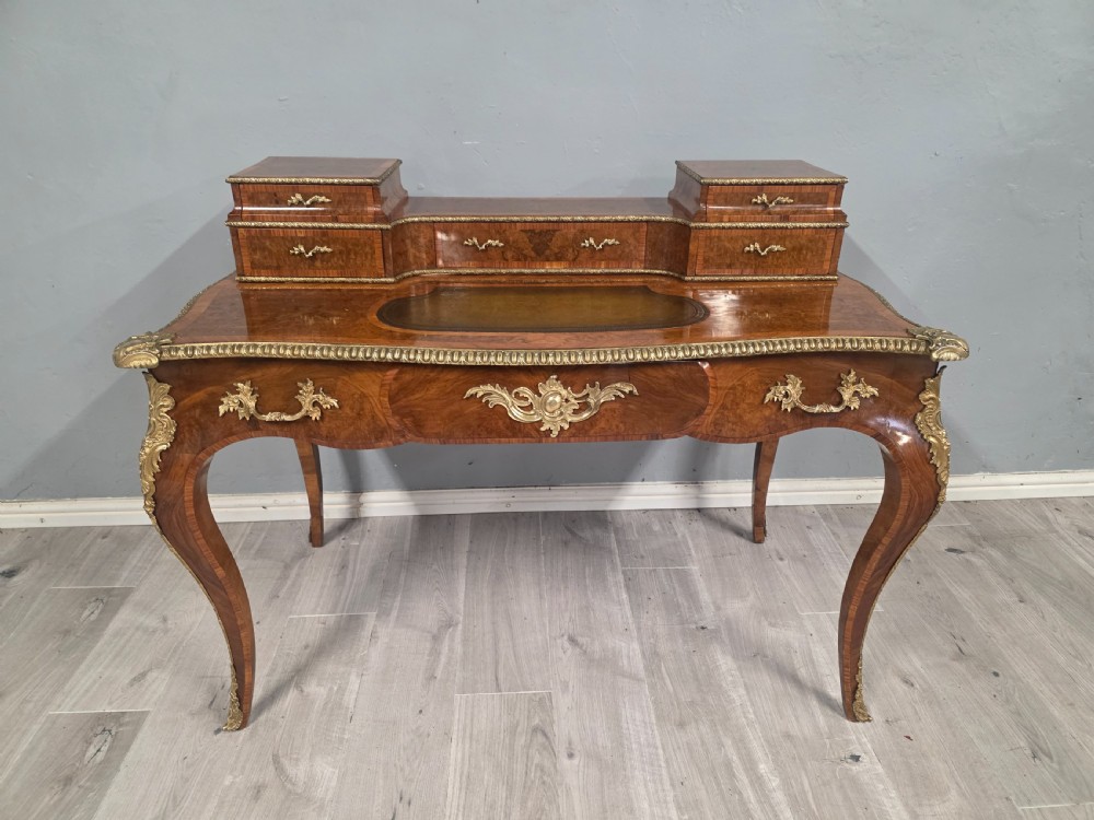 A 19th-century French Rococo Revival writing desk crafted from burr walnut with gilt-bronze mounts, a central leather writing insert, and a raised superstructure of drawers. View XIII