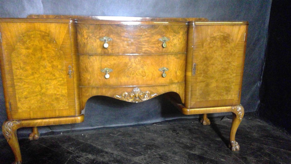 A burr walnut Queen Anne style sideboard featuring two central drawers flanked by cupboard doors, resting on carved cabriole legs with claw and ball feet. View IV