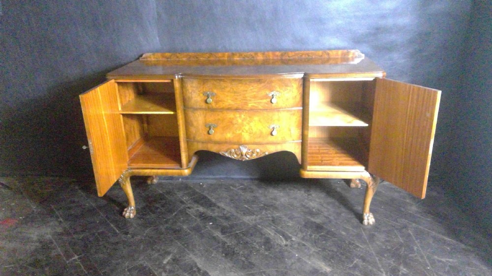 A burr walnut Queen Anne style sideboard featuring two central drawers flanked by cupboard doors, resting on carved cabriole legs with claw and ball feet. View VIII