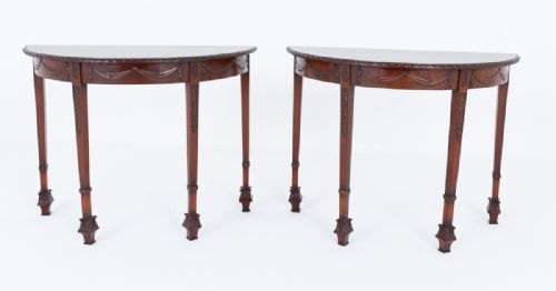 fig 2. A pair of demilune mahogany console tables with carved drapery aprons and slender tapered legs ending in decorative feet.