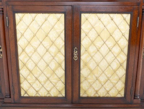 fig 2. A Georgian Revival walnut breakfront sideboard featuring three upper drawers over four cupboard doors, with central brass lattice inserts, raised on a plinth base.